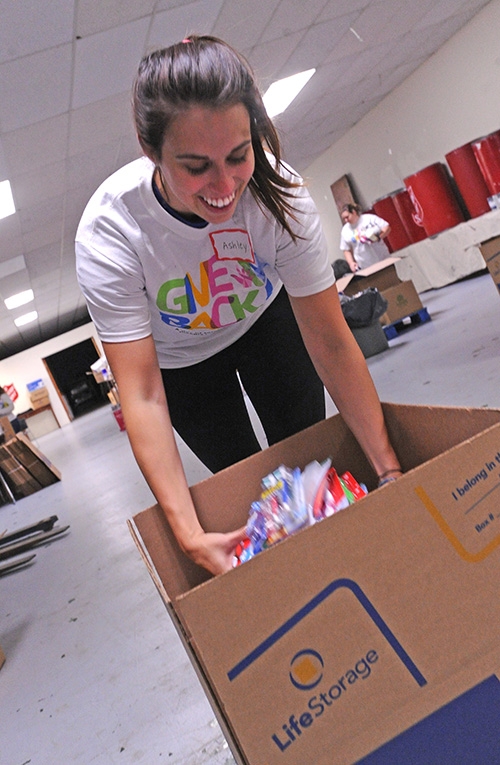 Volunteer Ashley Scapillato,of Citi Bank, prepares care packages Saturday morning at the Salvation Army, 960 Main Street, for the hurricane Henry relief effort. Difference makers from throughout Western New York  spread out around the Buffalo area to give back to the community with a few hours of service. (Dan Cappellazzo/Staff Photographer)
